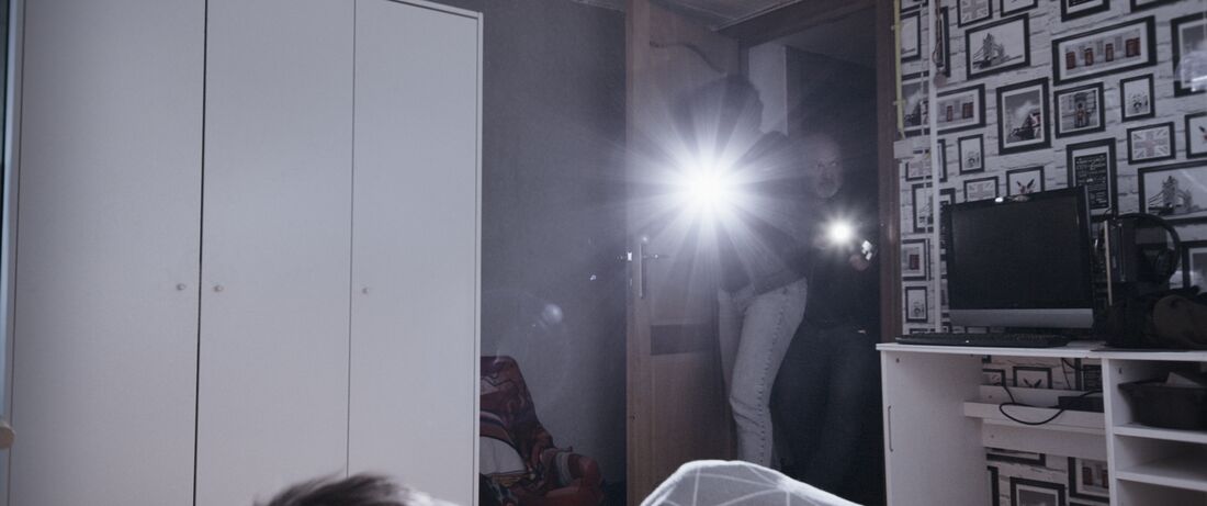 Deux hommes entrent dans une chambre d’enfant, lampes torches braquées